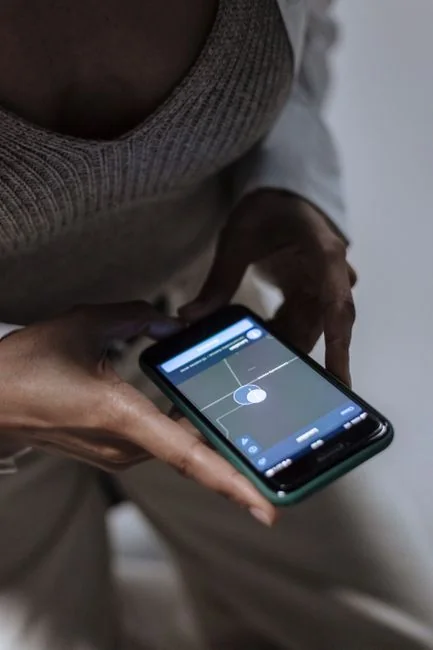 Gros plan sur un smartphone affichant une image floue, posé sur un bureau à côté d’un ordinateur portable.