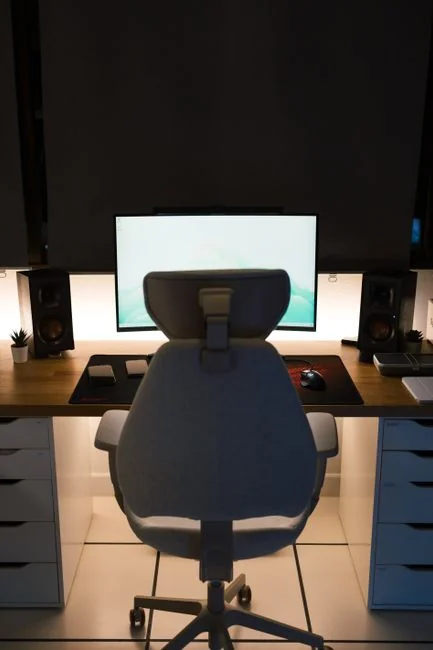 Vue d’en haut d’une personne sans visage consultant son téléphone mobile tout en travaillant à la maison, sur une table en marbre blanc avec des gadgets, un stylo et un crayon